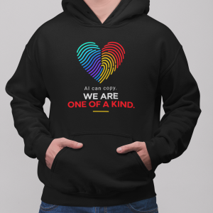Black hoodie with a rainbow heart graphic and text that reads 'AI can copy. WE ARE ONE OF A KIND.'